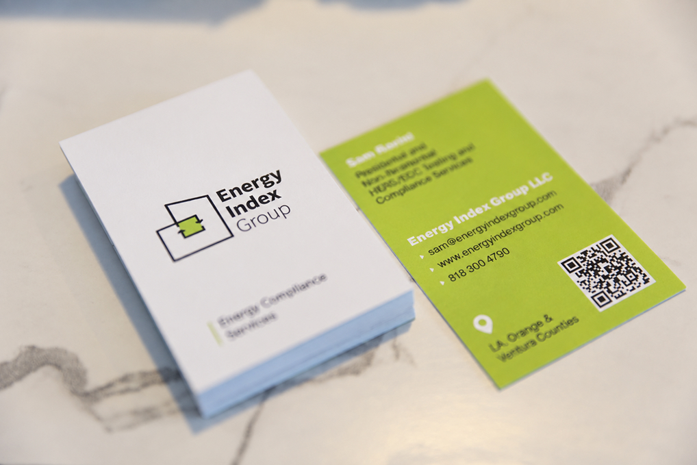 A clean, professional business card carries the house mark and the           charcoal-and-green brand palette into print — pairing the logo with           clear contact details so homeowners, HVAC contractors, and builders           can reach out to schedule a HERS test.